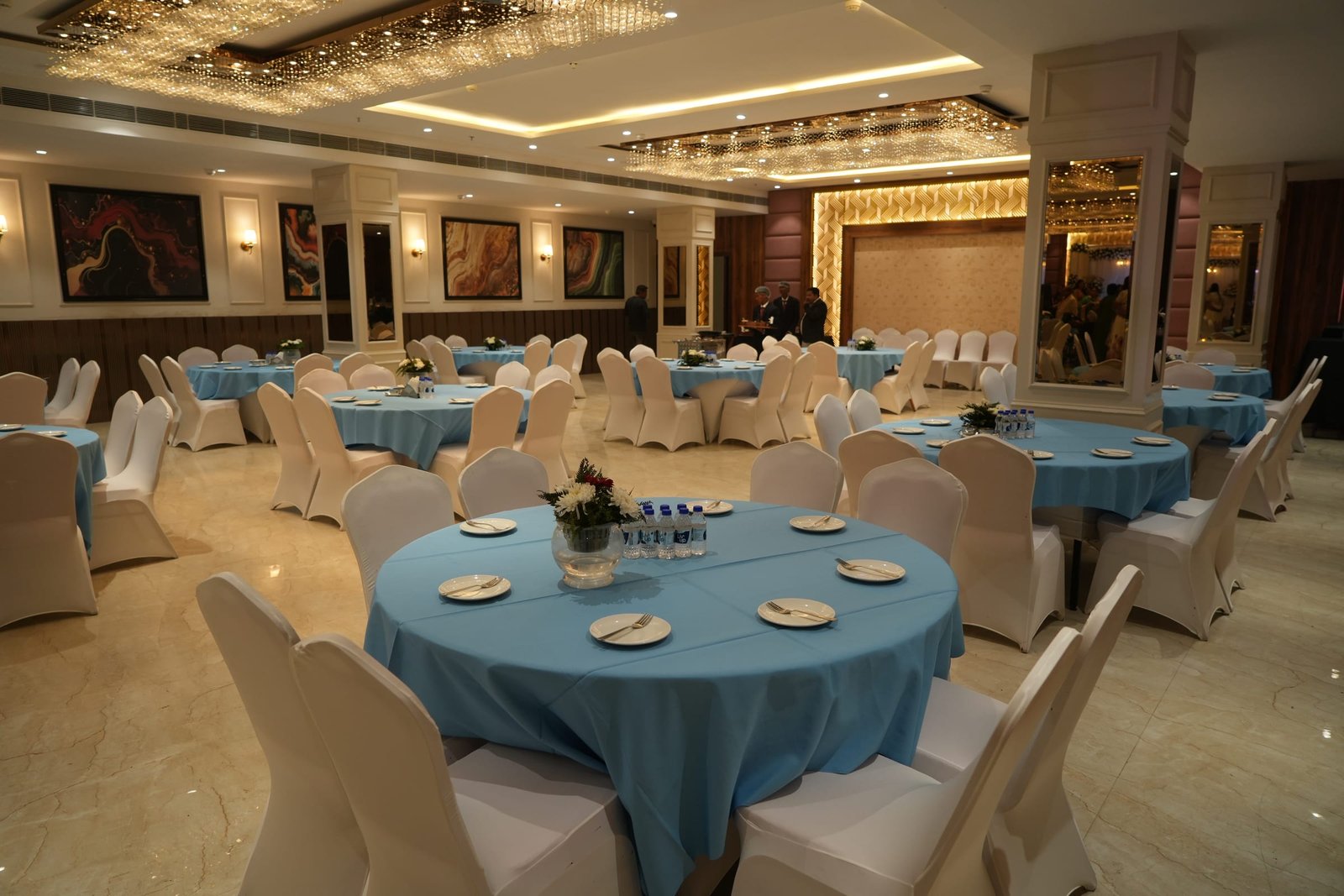 Banquet hall laid for a seated dinner under a crystal ceiling