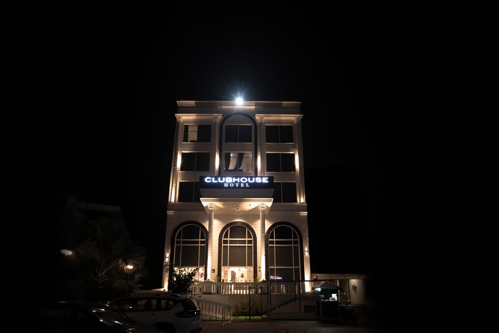 The Club House facade lit at night, arched windows above the entrance