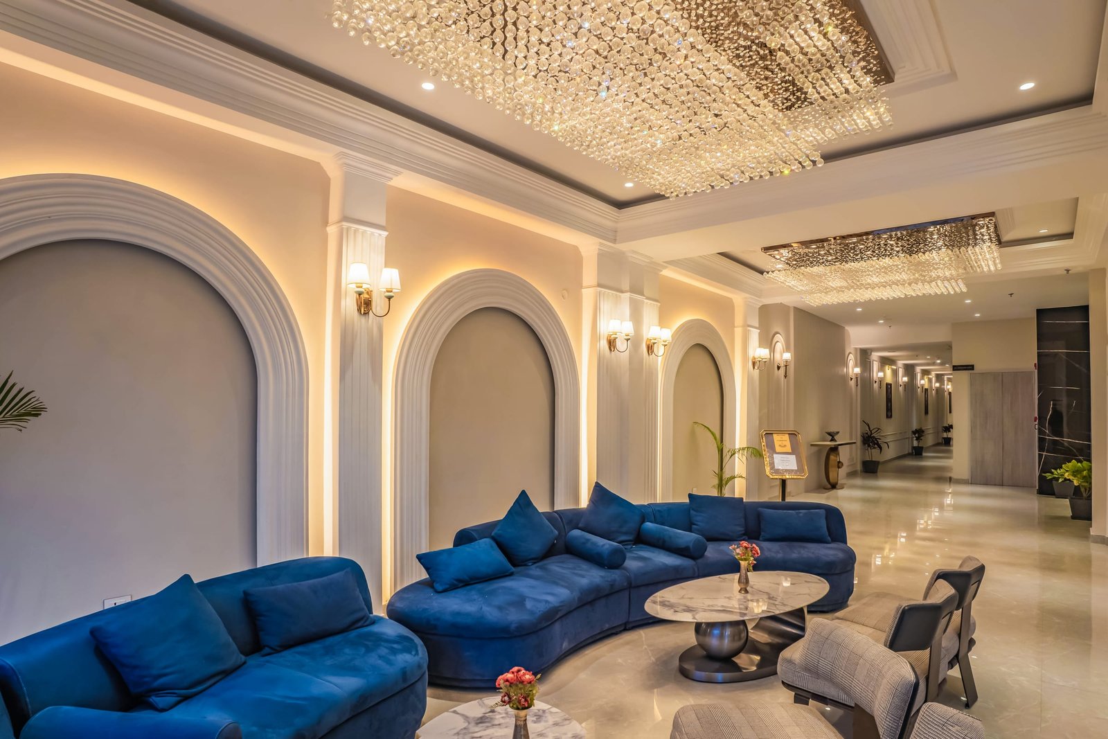 Lobby lounge with curved blue velvet seating under a crystal ceiling