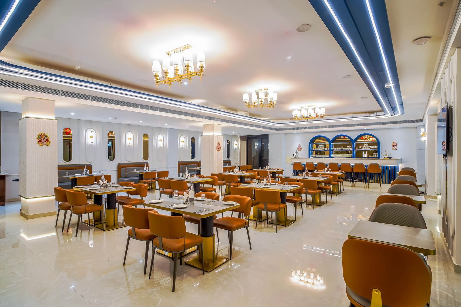 Restaurant dining room with set tables and a bar counter at the far end