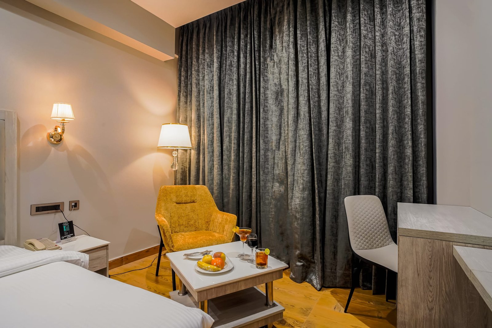 Room with a reading chair beside floor-length curtains