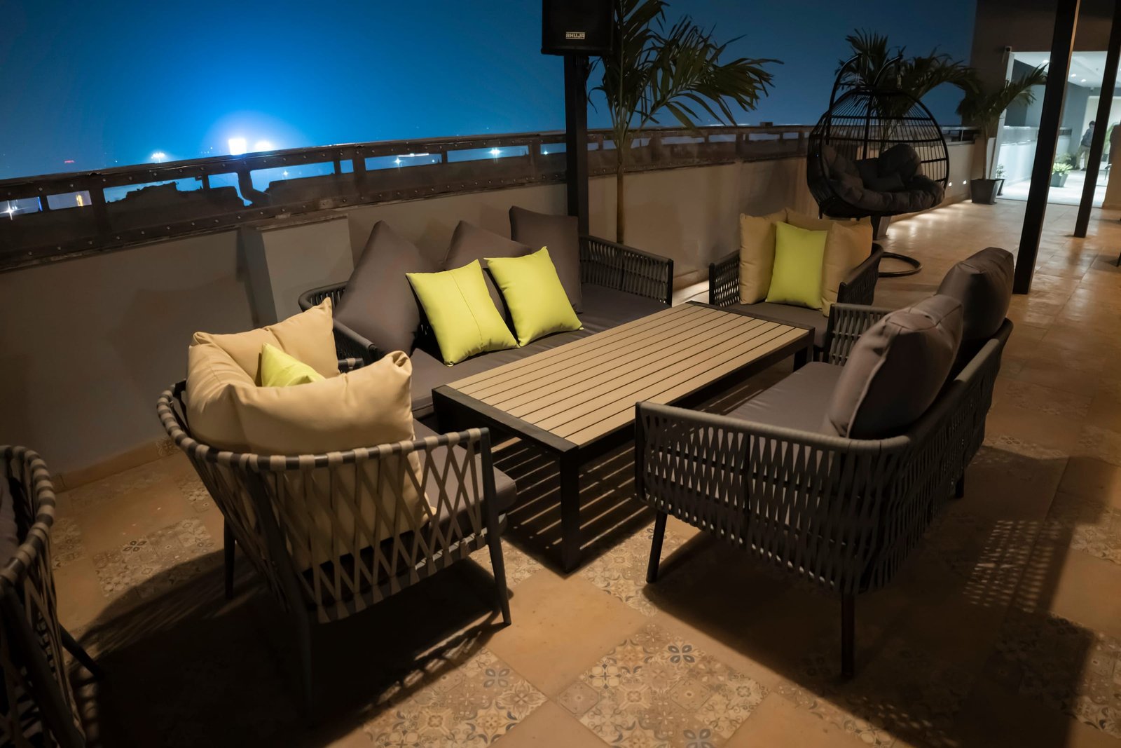 A low table and armchairs at the open end of the terrace