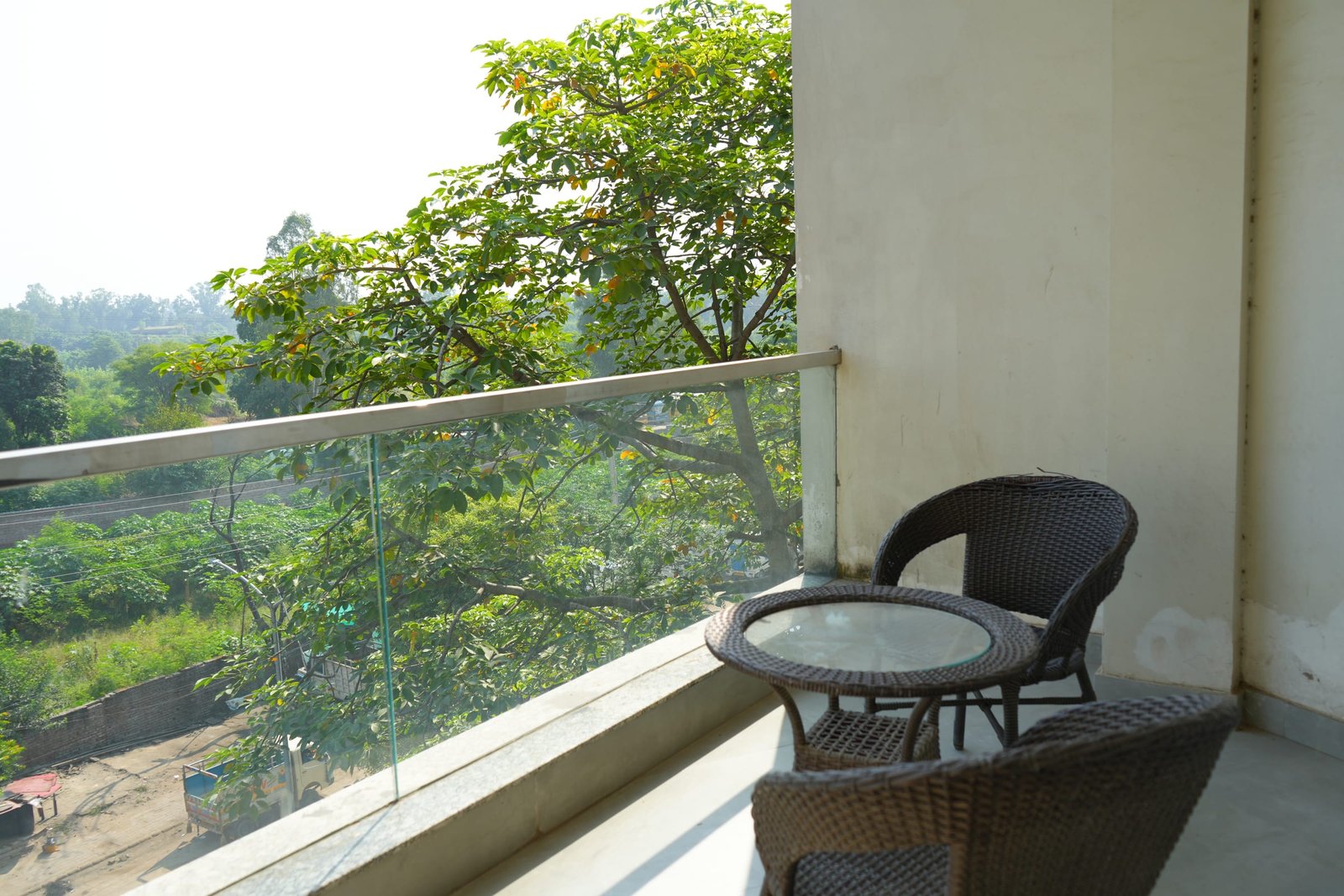A balcony table and chairs looking onto the trees