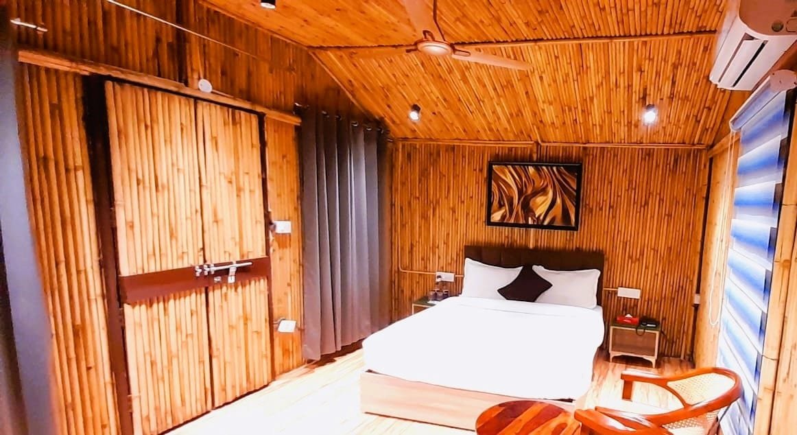 Inside a hut: bamboo walls and ceiling, cane chairs by the bed