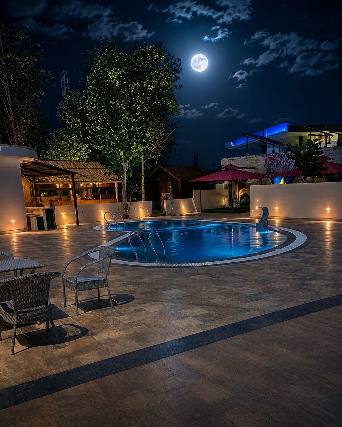 The pool lit at night under a full moon