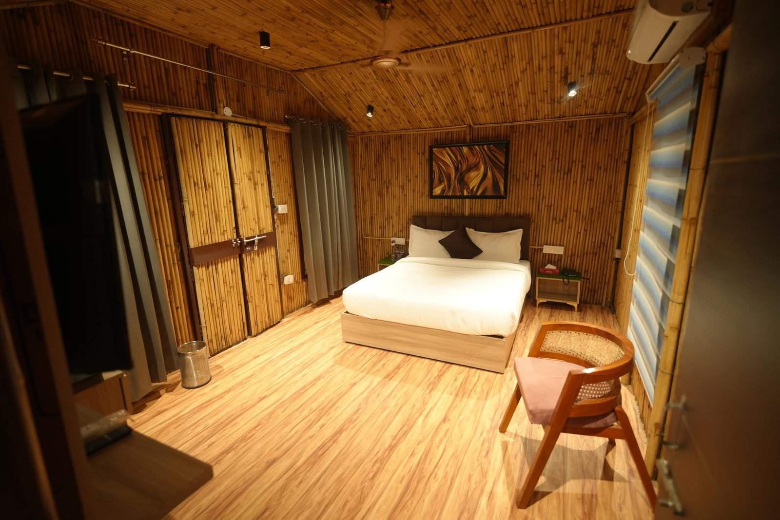 Bamboo-lined guest room with a double bed and timber flooring