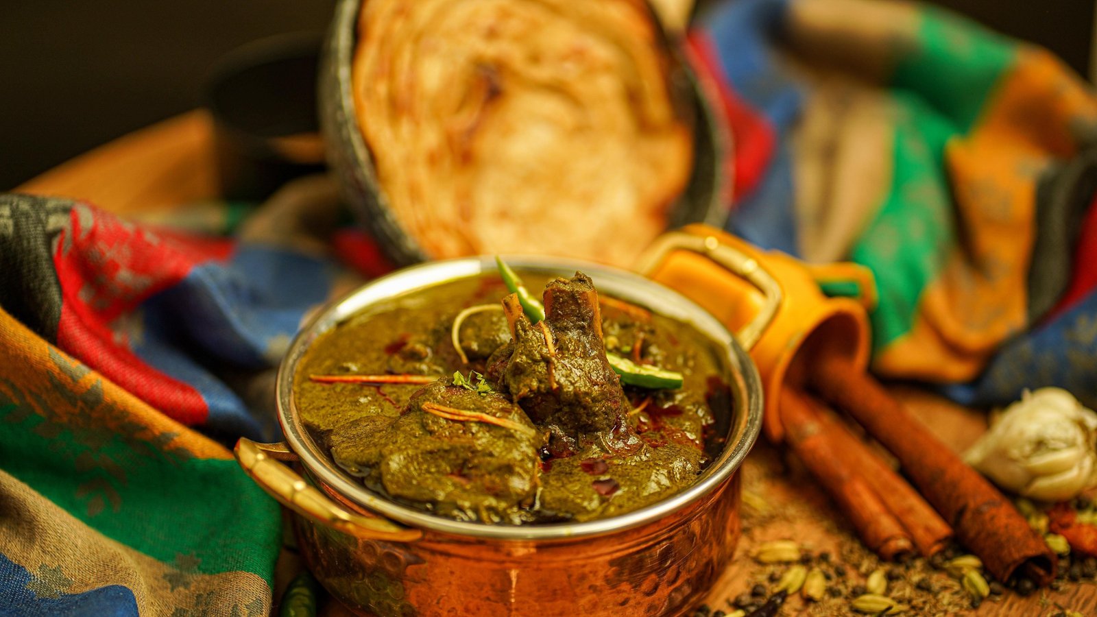 A mutton curry set out with whole spices