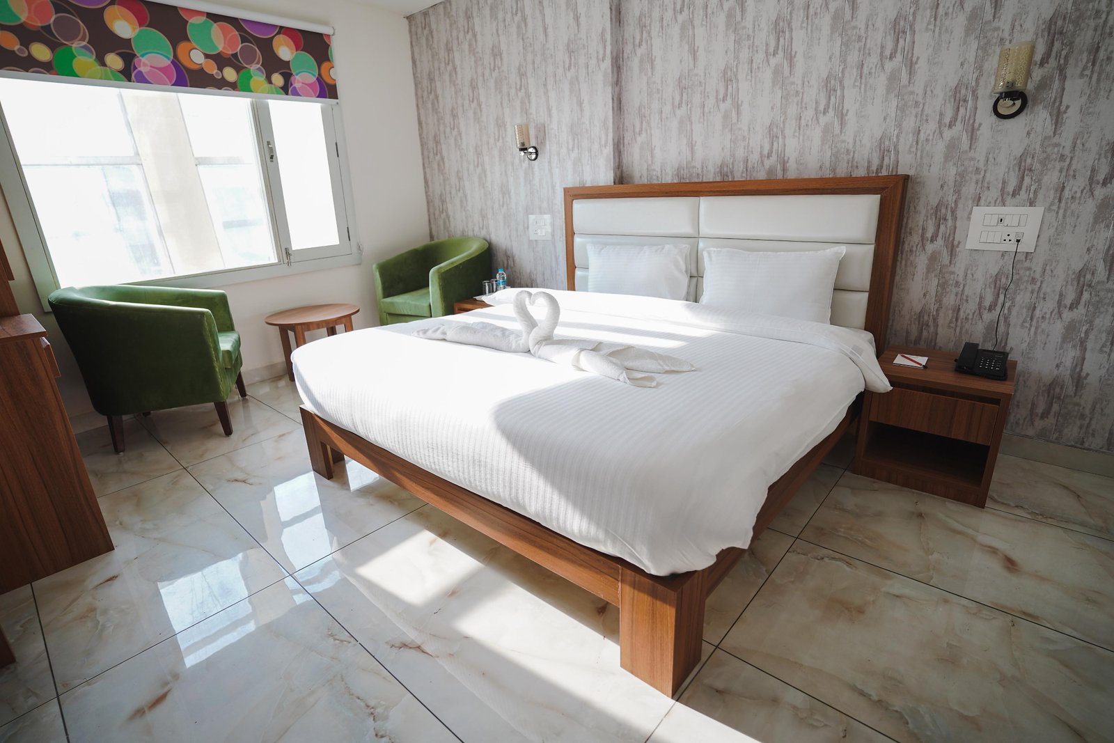 Guest room with green tub chairs at the window